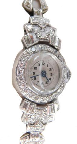 An Art Deco design ladies cocktail watch, with silver Arabic dial, blue hands, diamond set bezel and shoulders, with round brilliant and baguette cut stones, approx 1.48ct overall, white metal stamped 9ct and over stamped plat, 18.7g all in, in CJ Vinten 