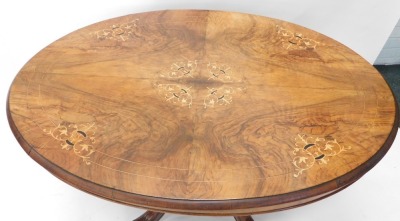 A Victorian walnut and inlaid loo table, the tilt top on a set of four heavily carved supports terminating in scroll feet with castors, 73cm high, 105cm wide, 85cm deep. - 3