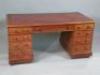 A mahogany pedestal desk with a red leather inset above an arrangement