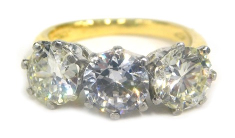 An 18ct gold three stone ring, set with two diamonds and one paste stone, the outer diamonds approx 6.29mm x 6.91mm, and 6.72mm x 6.71mm, each approx 1.24ct and 0.93ct respective, the centre paste stone approx 7.2mm x 7.26mm, ring size J½, claw set in a y