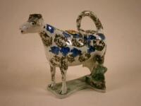 An early 19thC pearlware cow creamer in the form of a large blue brown