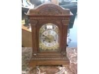 An early 20thC carved oak mantel clock