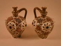 A pair of Zsolany Pecs type ewers each decorated in Persian style with flowers and leaves