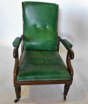 A George IV mahogany reclining armchair, upholstered in green leather, with a padded back, arm rest, seat, scroll carved supports, on turned tapering fluted legs, with brass castors. (AF) - 2