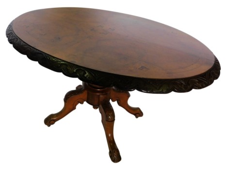 A Victorian walnut and marquetry oval loo table, the top with a carved shaped border, on a turned column and four leaf carved splayed legs, with castors, 69cm high, 114cm wide, 87cm deep.