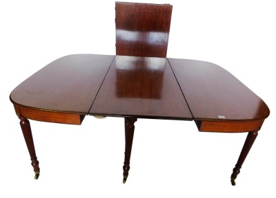 An early 19thC mahogany extending dining table, comprising two D shaped ends each with a moulded edge above an ebony strung frieze, on turned reeded legs with brass castors, and two loose leaves, 74cm high, 128cm wide, 240cm long overall.