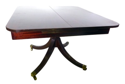 A mahogany extending dining table, the rectangular top with a reeded edge and rounded corners, opening to reveal a spring loaded leaf, on turned legs and reeded sabre legs, and brass castors, 72cm high, the top 106cm x 150cm.