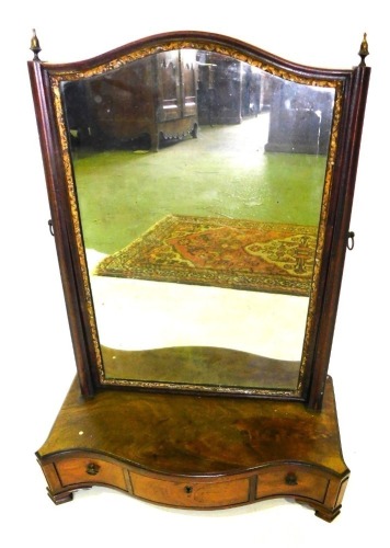 A mahogany dressing table mirror, the rectangular plate with a parcel gilt border, on plain channel supports, the serpentine fronted base with three frieze drawers, on ogee bracket feet, 61cm high, 44cm wide.