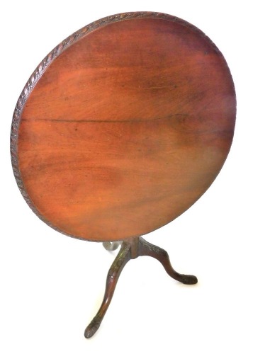 A 19thC mahogany tilt top supper table, the circular top with a carved border, on a turned column and carved tripod base, with pad feet, 86cm high, 87cm diameter.