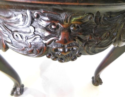 A mahogany centre table in mid 18thC style, with a circular top with a moulded edge, above an elaborately carved frieze with masks, scrolls, etc., on cabriole legs with ball and claw feet, 73cm high, 91cm diameter. - 2