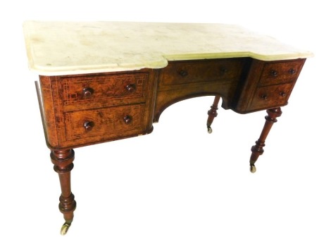 A Victorian figured walnut and boxwood strung inverted breakfront wash stand, the white marble top with a moulded edge, above five drawers around an arched recess, on turned legs with ceramic castors, 77cm high, 121cm wide, 53cm deep.