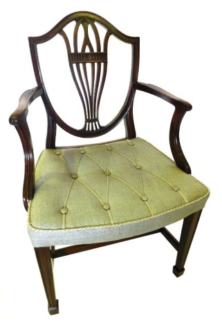 A mahogany open armchair in George III style, the shield shaped back with a pierced splat, with shaped arms, button padded seat, in grey fabric, on square tapering legs with H stretcher.