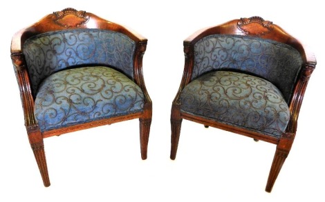 A pair of late 19th/early 20thC French oak tub shaped armchairs, upholstered in purple and grey scroll fabric, with stylized armorial carvings to the shaped back, moulded and beaded arm supports, on square tapering legs.