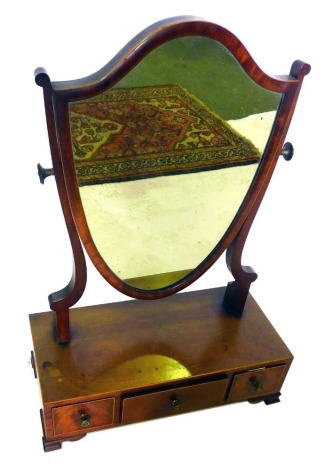 A 19thC mahogany and boxwood strung dressing table mirror, the shield shaped back with shaped supports, the rectangular base with three drawers, on ogee bracket feet, 67cm high, 45cm wide.