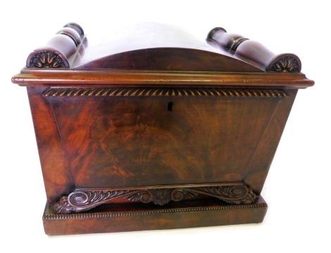 A George IV figured mahogany sarcophagus shaped cellarette, with a domed top hinged to reveal a vacant interior, the front with a raised panel and stylized paw feet, on a plinth with beaded edge, 42cm high, 58cm wide, 42cm deep.