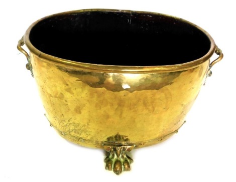 A late 19th/early 20thC oval brass coal bucket, with side handles, on paw feet, 46cm wide.