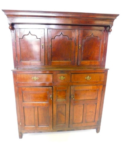 A late 17th/early 18thC oak deudarn, with a moulded cornice with turned drop finials, above three panelled doors, the base with two long and one short drawer, and two panelled doors, on stiles, 142cm high, 132cm wide, 53cm deep.