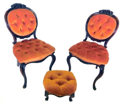 A set of six 19thC rosewood balloon back chairs, each with a flower carved crest, an orange velvet upholstered button back and seat, on cabriole legs, and an upholstered footstool to match.