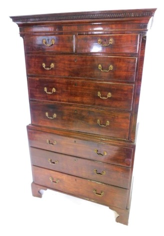 A George III mahogany chest on chest, the top with a dentil cornice above two short and three long drawers, flanked by canted corners, the base with a further four long drawers, on bracket feet, 183cm high, 105cm wide.