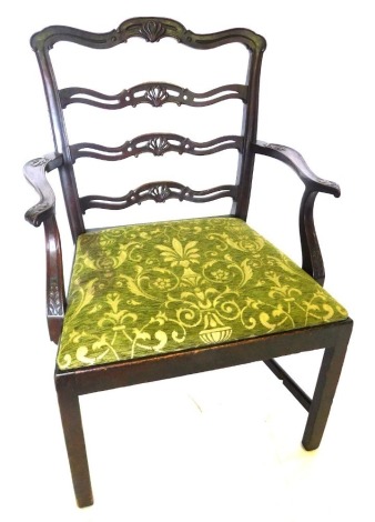 A late 19th/early 20thC mahogany elbow chair, the pierced ladder back carved with acanthus, the drop in seat upholstered in green and gold fabric, with shaped arms, on chamfered legs with H stretcher.