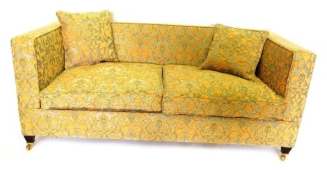 A pair of modern sofas, upholstered in coral and grey patterned fabric, with loose cushions, on square tapering legs and brass castors, 186cm wide.