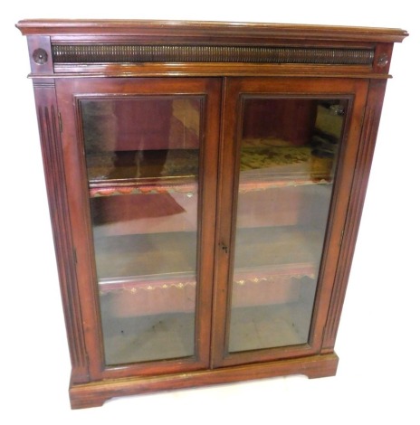 A late Victorian mahogany bookcase, enclosed by two glazed doors and having two adjustable shelves, raised on bracket feet, 115cm high, 91cm wide, 33cm deep.