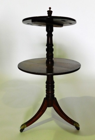 A 19thC mahogany two tier dumbwaiter, each circular drop leaf section supported by a ring tuned column and sabre legs, with brass castors, 115cm high, 58cm wide. (finial AF)