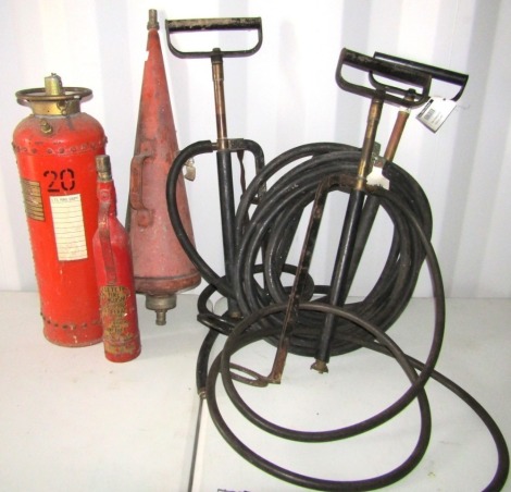 Three stirrup pumps and three vintage fire extinguishers.