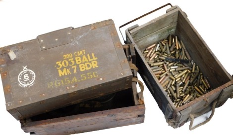 Three military ammo boxes and associated brass shell cases.