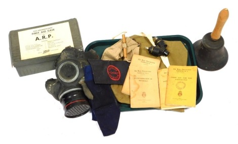 A selection of World War II Home Front items, to include gas mask, fire guard arm bands, ARP first aid case, etc.