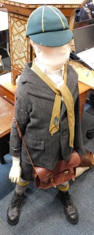 A small child mannequin, dressed in wartime style clothing.