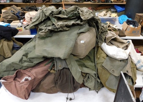 A large selection of military ground sheets, tent parts, etc.