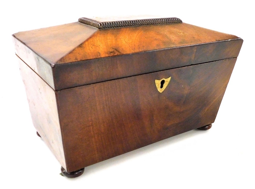 A Regency mahogany sarcophagus form tea caddy, the hinged lid opening ...