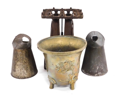 A Qing Dynasty bronze urn, embossed with magnolias, 18cm high (AF), together with a cast iron stove, and two one litre oil cans. (4) - 5