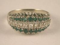 A tiny emerald and diamond set three row dress ring in white metal