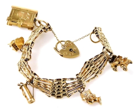 A 9ct gold gate charm bracelet, with five charms as fitted, on a heart shaped padlock clasp, with safety chain as fitted, 28.3g.