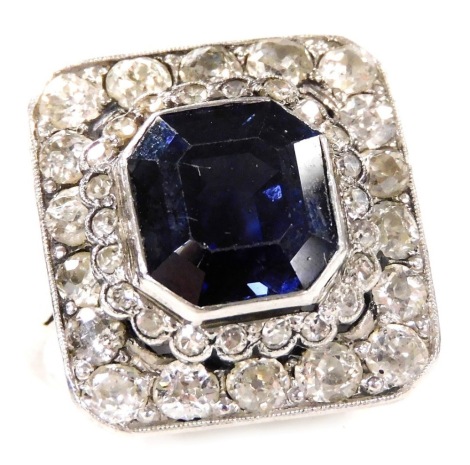 A sapphire, diamond and platinum ring, the canted rectangular central sapphire collet set in a two tiered surround of twenty-four small and eighteen larger rose cut diamonds, the sapphire approximately 5.5ct, diamonds approximately 2.5ct, size M, 6.9g.