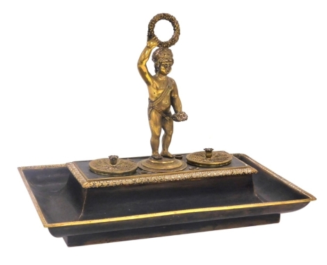 A late 19thC French bronze and brass encrier, of rectangular form, with a central carrying figure of a putto, flanked by a brass lidded inkwell and pounce pot, 28cm wide.