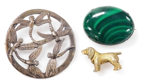 An Edward VII silver gilt brooch, modelled as a Labrador, Birmingham 1902, silver circular brooch decorated with dragonflies, and an oval cabochon malachite brooch, in a white metal frame stamped 800. (3)