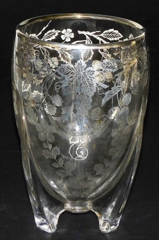 An early 20thC glass and silver overlay vase, of cylindrical tapering form, decorated with leaves vines and fruit, etched floral decoration to lower section, raised on a triform base, silver work marked sterling, 23cm high.