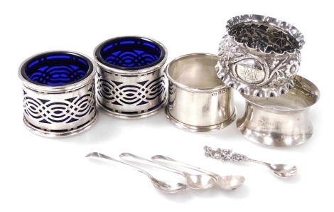 A pair of 20thC Indian Colonial silver open salts, with pierced decoration and blue glass liners, Hamilton and Co., together with three silver napkin rings for Birmingham 1909 and 1919 and a floral embossed example for Chester 1896, and four salt spoons t