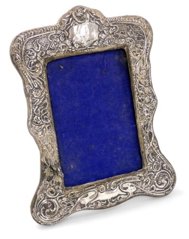 An Edward VII silver strut photograph frame, embossed with flowers and foliate scrolls, aperture 12.5cm x 8.5cm, frame 21cm x 16.5cm, Chester 1905. (AF)