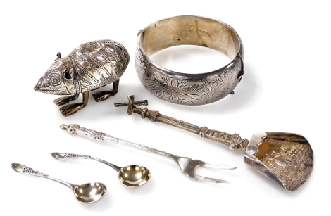 A group of small silver, to include an Elizabeth II silver bangle, bright cut decorated with flowers and leaves, Birmingham 1965, together with two salt spoons, a pickle fork, a Continental silver sugar shovel, possibly Dutch, and a white metal figure of 