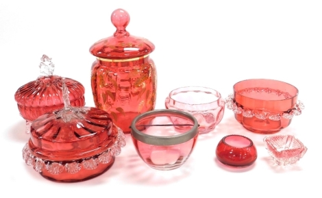 A group of Victorian and later cranberry coloured glass ware, to include bon bon dish and cover, 17cm high, another, jar and cover, with raised floral decoration, 24cm high, etc. (1 tray)