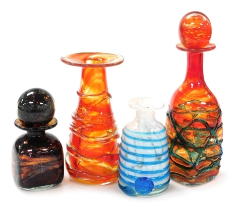 A group of Mdina glassware, to include an ink bottle, of square form with a flared rim and globular stopper, with flashes of purple and pale green against a purple glass ground, 16cm high, a further ink bottle, lacking stopper, 14cm high, etc.