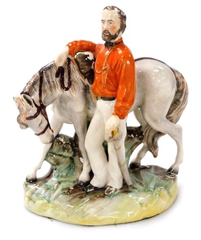 A late 19thC Staffordshire flatback figure group modelled as Garibaldi, modelled standing against his horse, raised on a naturalistic ground, 21cm wide.