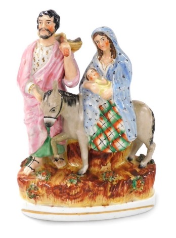 A 19thC Staffordshire flatback figure group, modelled as Joseph, Mary on a donkey with the baby Jesus in her arms, raised on a naturalistic oval base, 21cm high.