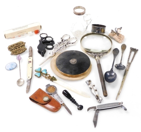 A group of collectables, to include a mid century Stratton powder compact, silver napkin ring, magnifying glass, an agate seal with swivel movement, 6cm long, various plated souvenir spoons, etc. (1 tray)