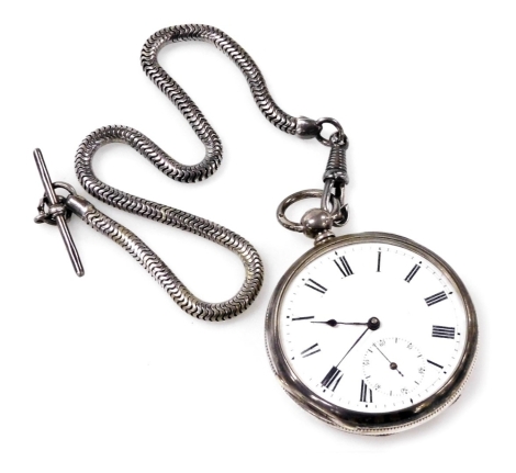 A late 19thC gentleman's silver cased pocket watch, open faced, key wind, circular enamel dial bearing Roman numerals, subsidiary seconds dial, the case with engine turned decoration, vacant shield reserve, on a silver Albert chain with t-bar as fitted, 1