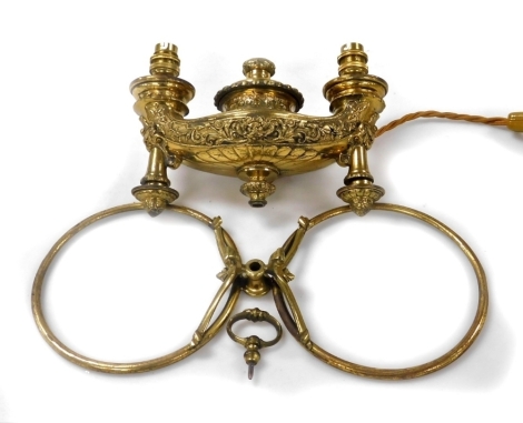 A Victorian brass hanging twin branch gasolier, converted to electricity, of Roman oil lamp form, embossed with flowers and scrolling leaves, 26cm wide.